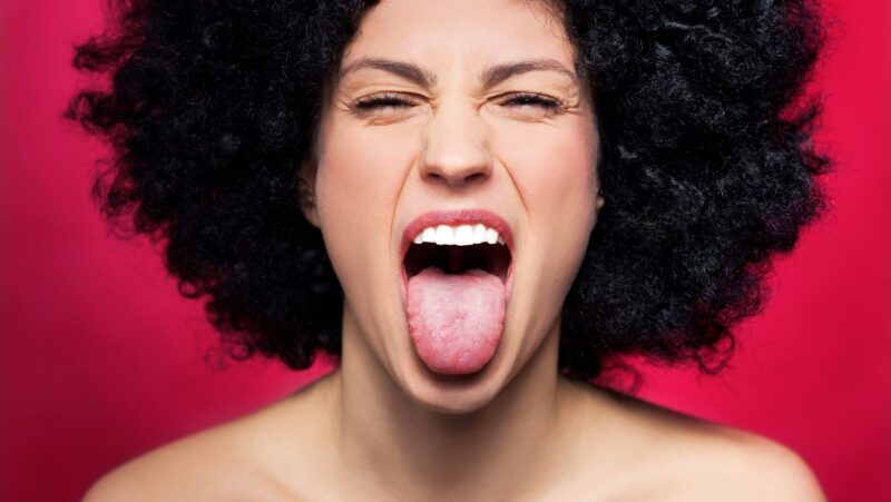what does it mean when a girl sticks her tongue out to the side